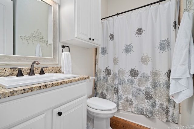 full bathroom with shower / tub combo, wood-type flooring, vanity, and toilet