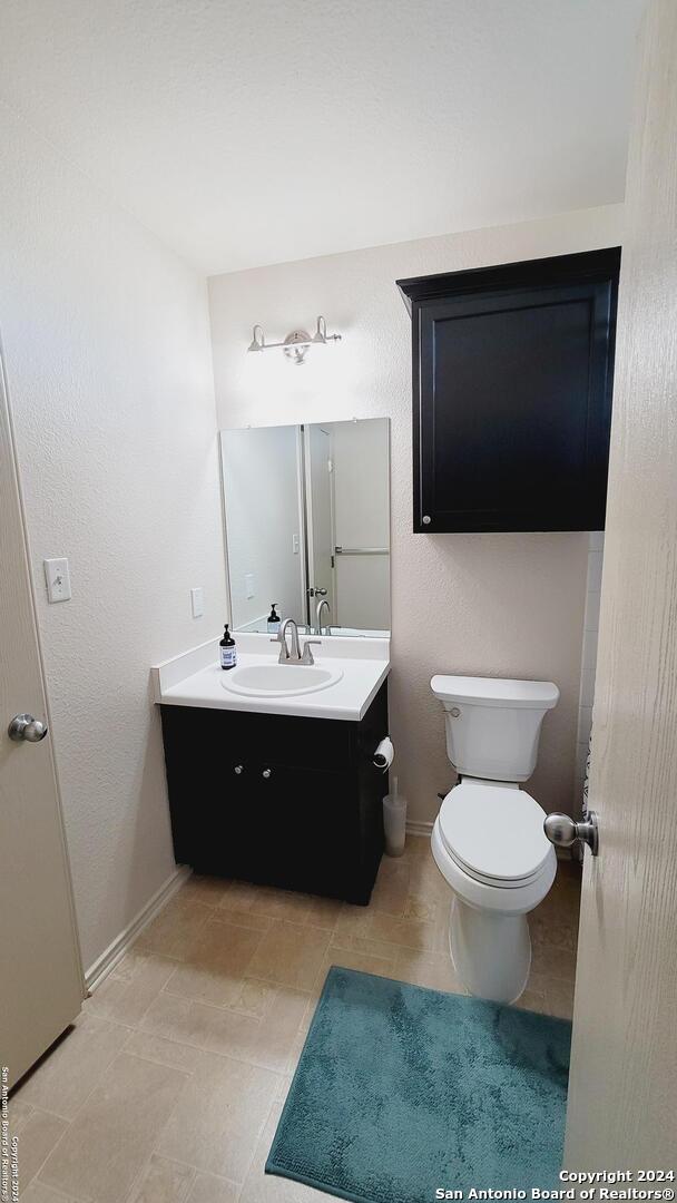 bathroom featuring tile patterned floors, vanity, and toilet