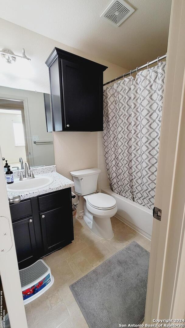 full bathroom featuring vanity, toilet, and shower / bathtub combination with curtain