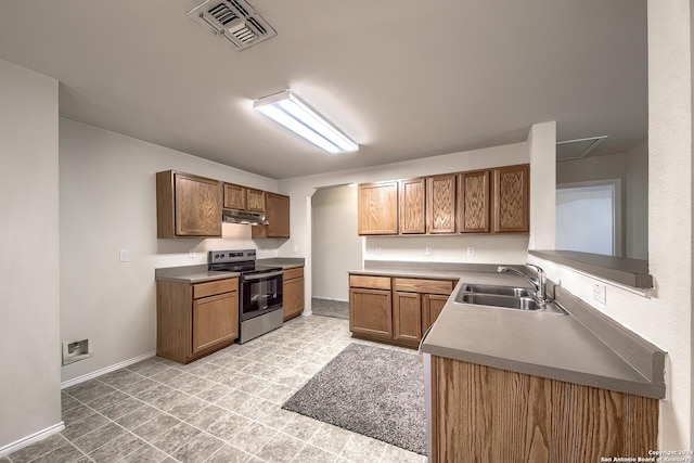 5823 Barton Holw, San Antonio, TX 78249 - kitchen featuring stainless steel electric range, a sink, under cabinet range hood, brown cabinetry, and baseboards