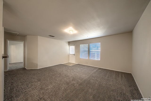 spare room with dark carpet