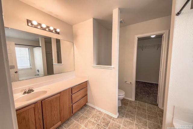 5823 Barton Holw, San Antonio, TX 78249 - bathroom featuring toilet, vanity, a walk in closet, and baseboards