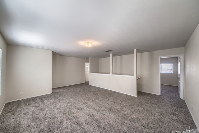 unfurnished room with dark colored carpet