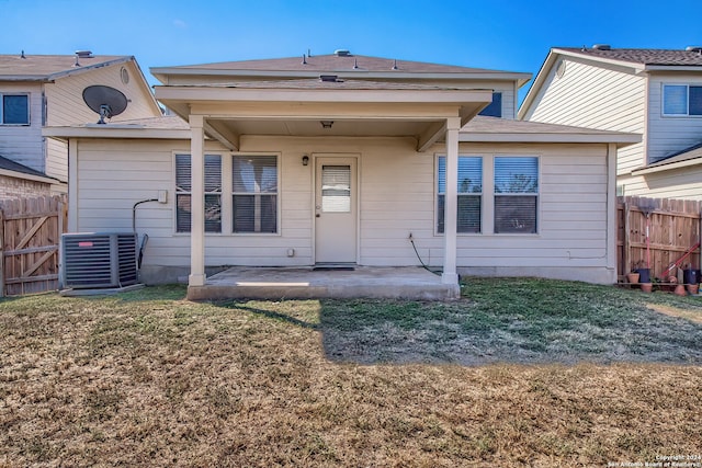 back of property featuring a patio, a yard, and central AC