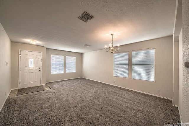 interior space featuring an inviting chandelier and a textured ceiling