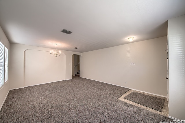 spare room with carpet and a chandelier