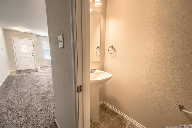 5823 Barton Holw, San Antonio, TX 78249 - bathroom featuring baseboards, a textured wall, and tile patterned flooring