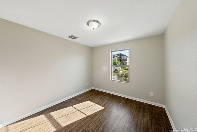 spare room with dark wood-type flooring