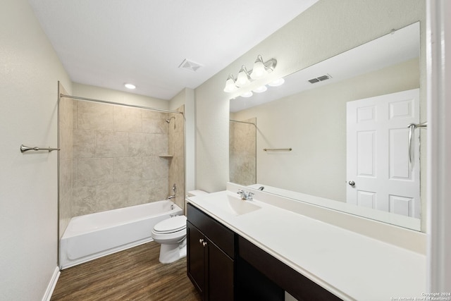 full bathroom featuring tiled shower / bath, hardwood / wood-style flooring, vanity, and toilet