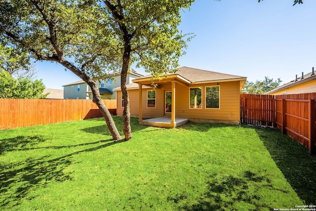 rear view of property featuring a yard