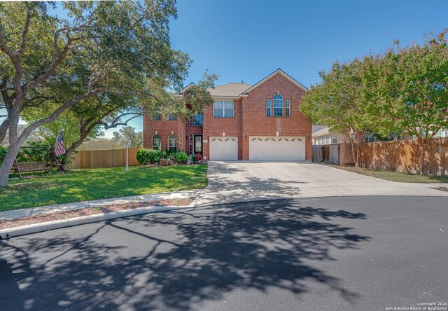 3303 Cambria Way, San Antonio, TX 78251 - traditional-style home with a front yard, driveway, brick siding, an attached garage, and fence