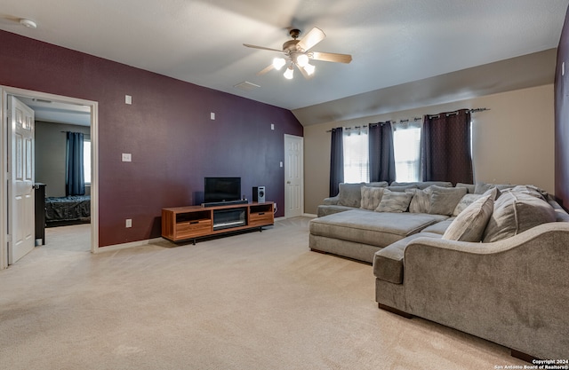 living room featuring lofted ceiling, ceiling fan, and light colored carpet