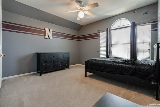 bedroom featuring multiple windows, lofted ceiling, light carpet, and ceiling fan