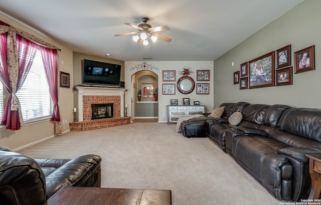 carpeted living room featuring ceiling fan and a brick fireplace