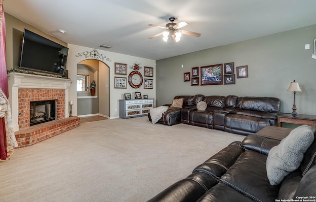 3303 Cambria Way, San Antonio, TX 78251 - carpeted living room with a fireplace, a ceiling fan, visible vents, baseboards, and arched walkways