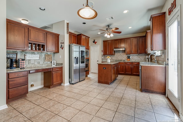 kitchen with light stone counters, a center island, light tile patterned flooring, decorative backsplash, and appliances with stainless steel finishes