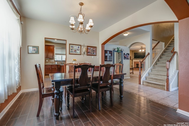 dining room with hardwood / wood-style flooring and ceiling fan with notable chandelier