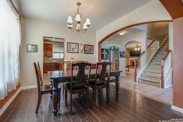 3303 Cambria Way, San Antonio, TX 78251 - dining room featuring arched walkways, an inviting chandelier, baseboards, stairway, and wood tiled floor