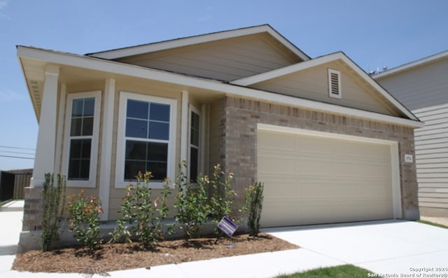 view of front facade featuring an attached garage, concrete driveway, and brick siding