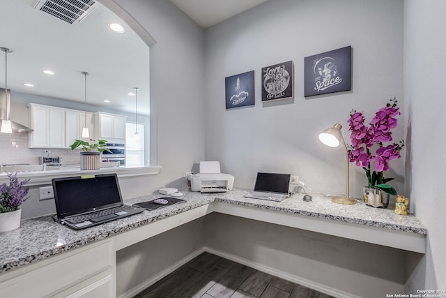 office area with built in desk and dark wood-type flooring