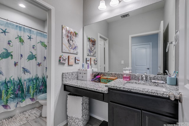 bathroom with hardwood / wood-style floors, vanity, toilet, and a shower with curtain