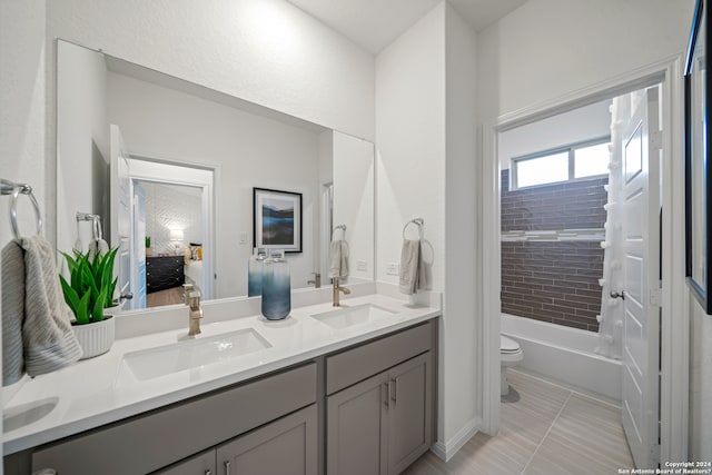 full bathroom with tile patterned floors, vanity, tiled shower / bath combo, and toilet