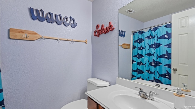 bathroom with a shower with curtain, vanity, a textured ceiling, and toilet