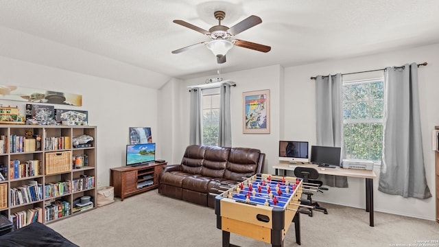 carpeted office space featuring a textured ceiling, vaulted ceiling, and ceiling fan