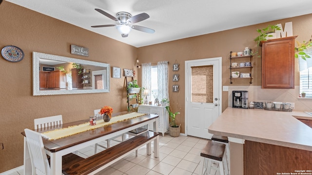 tiled dining area with a wealth of natural light and ceiling fan