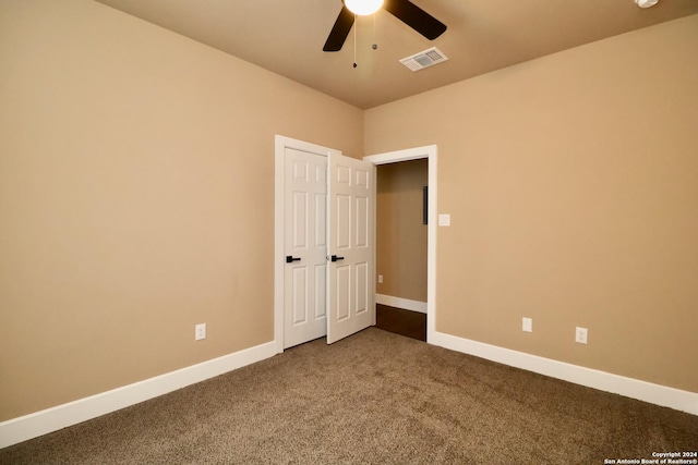 spare room with ceiling fan, carpet floors, visible vents, and baseboards