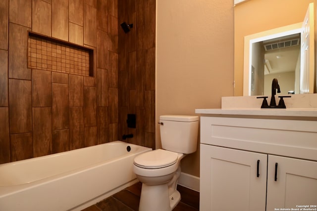 full bathroom featuring tiled shower / bath, vanity, and toilet