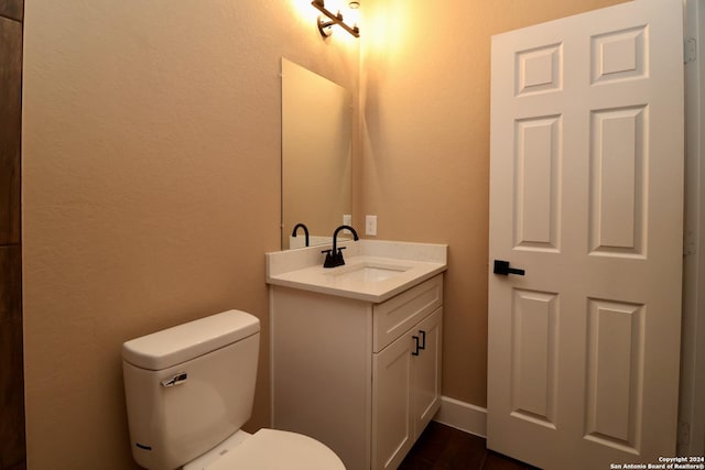 half bathroom with toilet and vanity