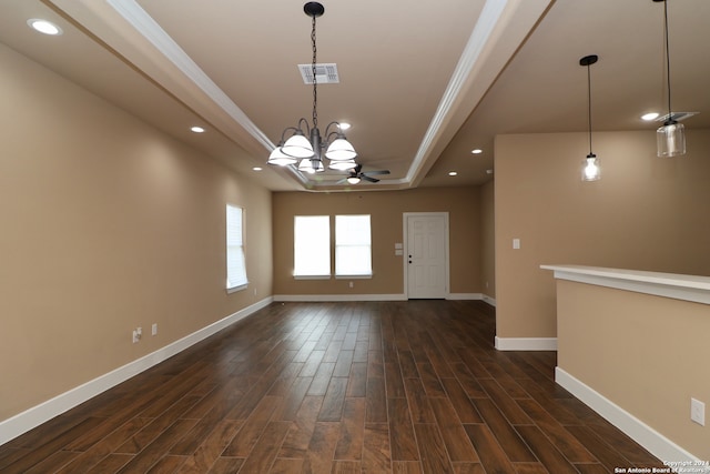 spare room with ornamental molding, ceiling fan with notable chandelier, a raised ceiling, and dark hardwood / wood-style flooring