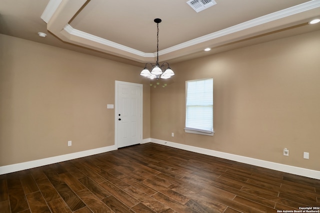 unfurnished room featuring ornamental molding, a notable chandelier, a raised ceiling, and dark wood-type flooring