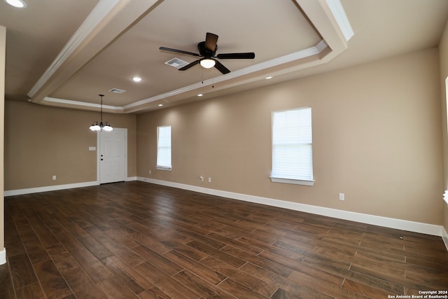 spare room with ceiling fan with notable chandelier, a raised ceiling, and dark hardwood / wood-style floors