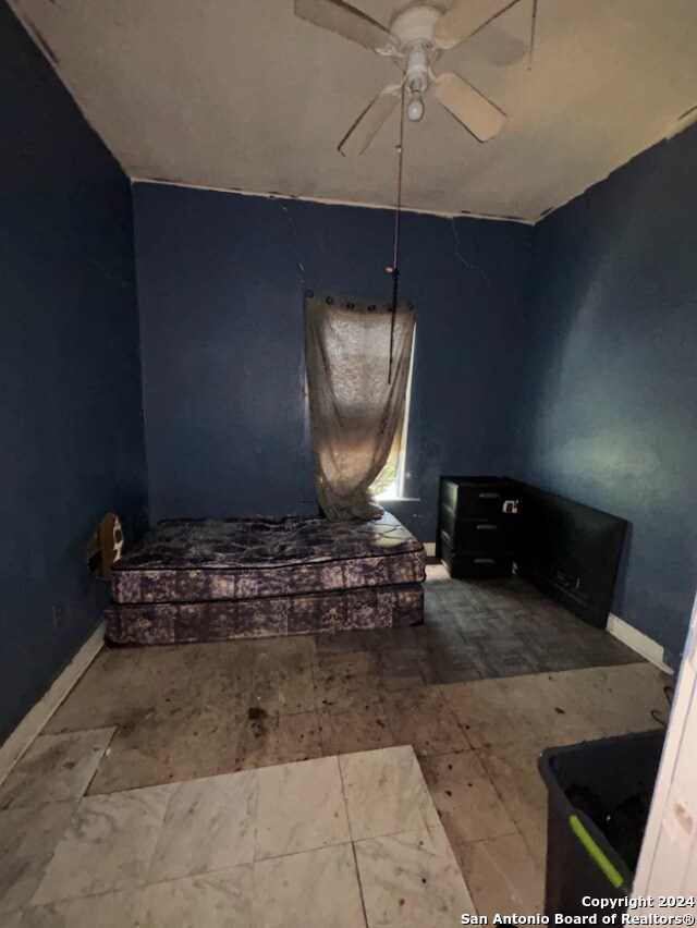 bathroom with a ceiling fan and baseboards