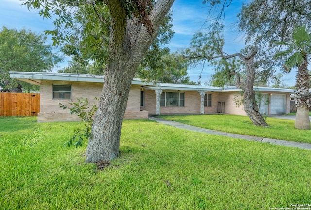 single story home featuring a front lawn and a garage