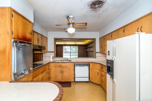 kitchen with a textured ceiling, white appliances, ceiling fan, and sink