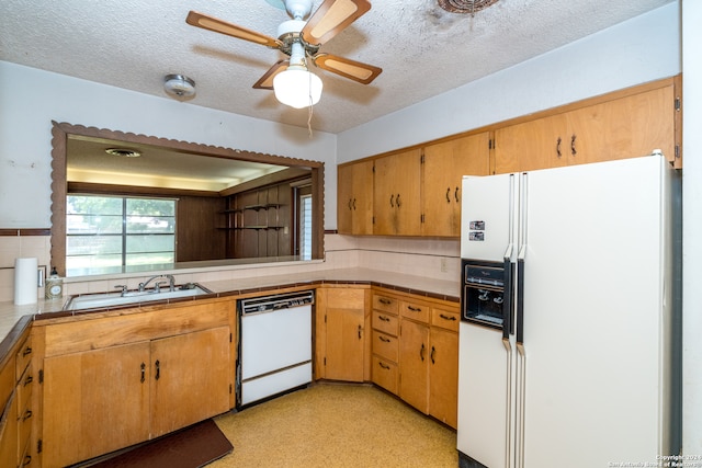 kitchen featuring ceiling fan, sink, white appliances, a textured ceiling, and decorative backsplash