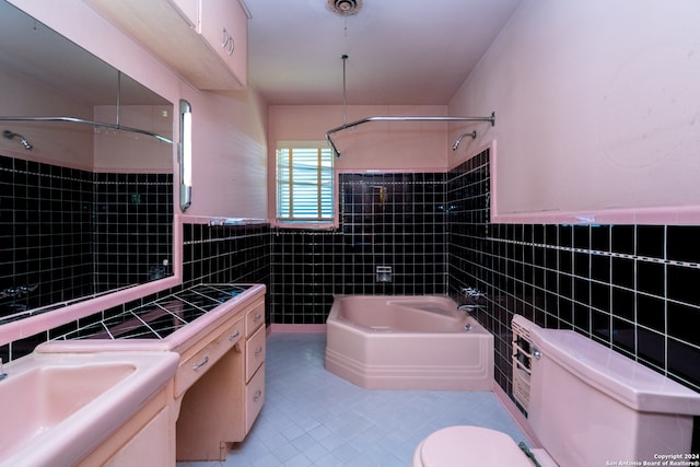 full bathroom with tile walls, vanity, tile patterned flooring, shower with separate bathtub, and toilet