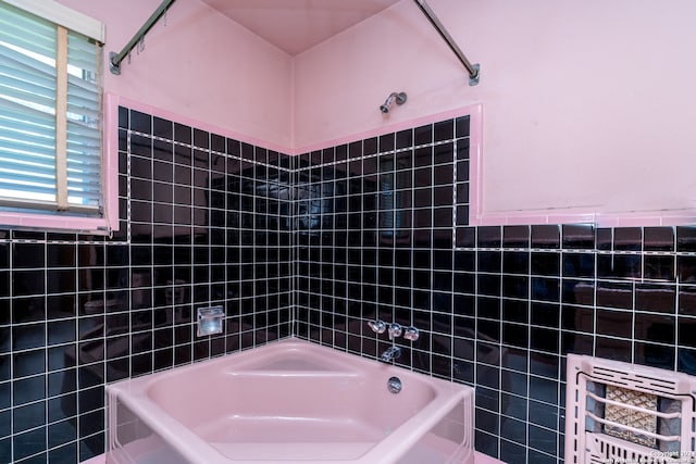 bathroom featuring tile walls and tiled shower / bath