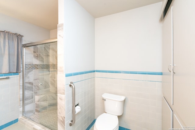 bathroom with tile walls, a shower with door, and toilet