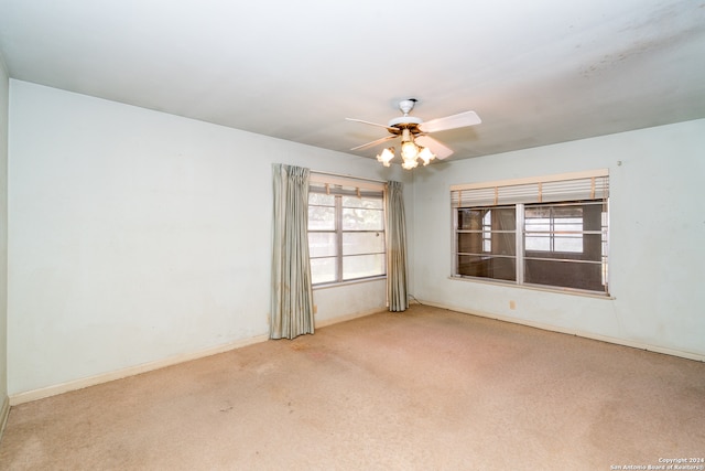 carpeted spare room with ceiling fan