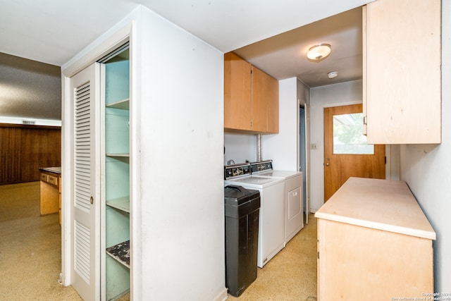 laundry room featuring separate washer and dryer and cabinets