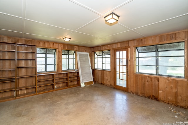 empty room featuring wood walls and concrete flooring