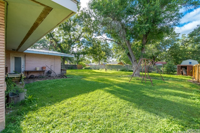 view of yard with a playground and a storage shed