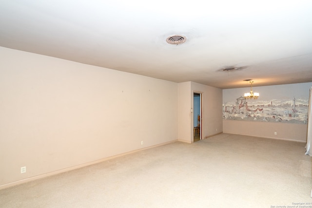 carpeted empty room featuring a notable chandelier