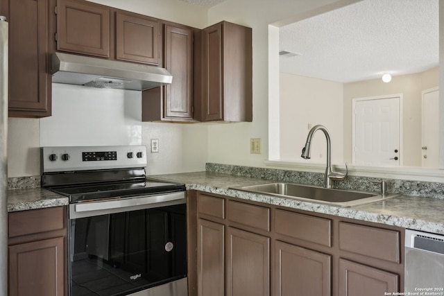 kitchen featuring appliances with stainless steel finishes, a textured ceiling, and sink