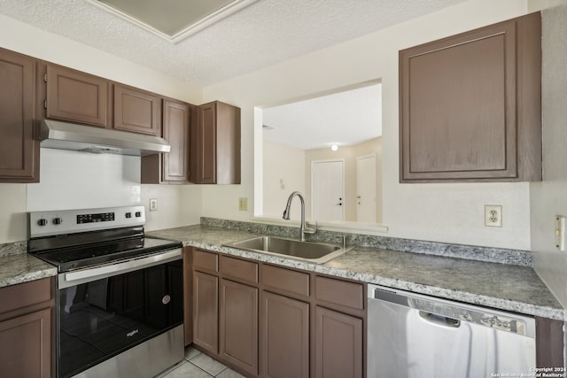 kitchen featuring stainless steel appliances, a textured ceiling, light tile patterned floors, and sink