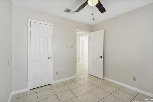 unfurnished bedroom featuring light tile patterned floors, ceiling fan, and a closet